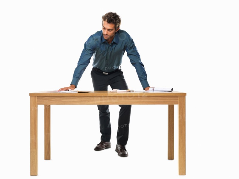 Portrait of smart business man standing with palms on table. Photo : momentimages