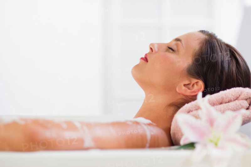 Young woman taking bath.