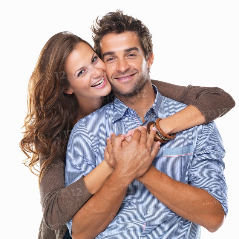 Studio shot of young couple smiling and embracing. Photo : momentimages