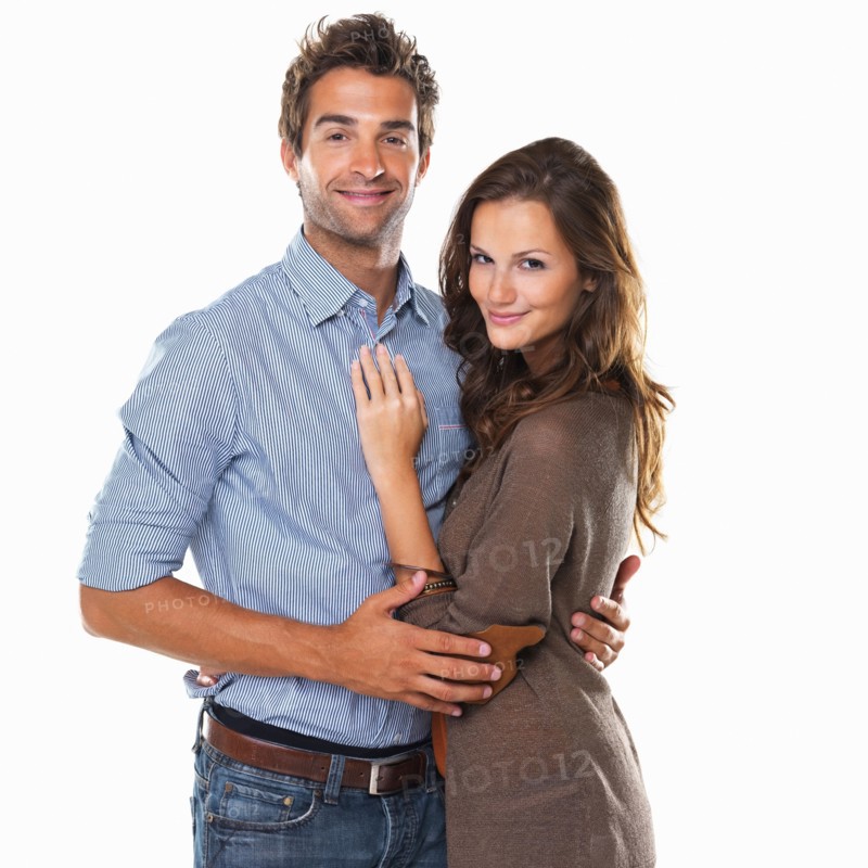 Studio shot of young attractive couple smiling. Photo : momentimages