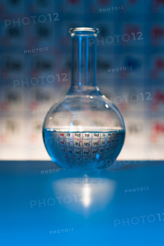 Beaker with periodic table in laboratory.