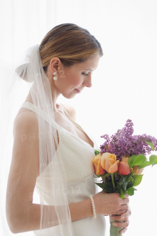 Bride holding floral bouquet.