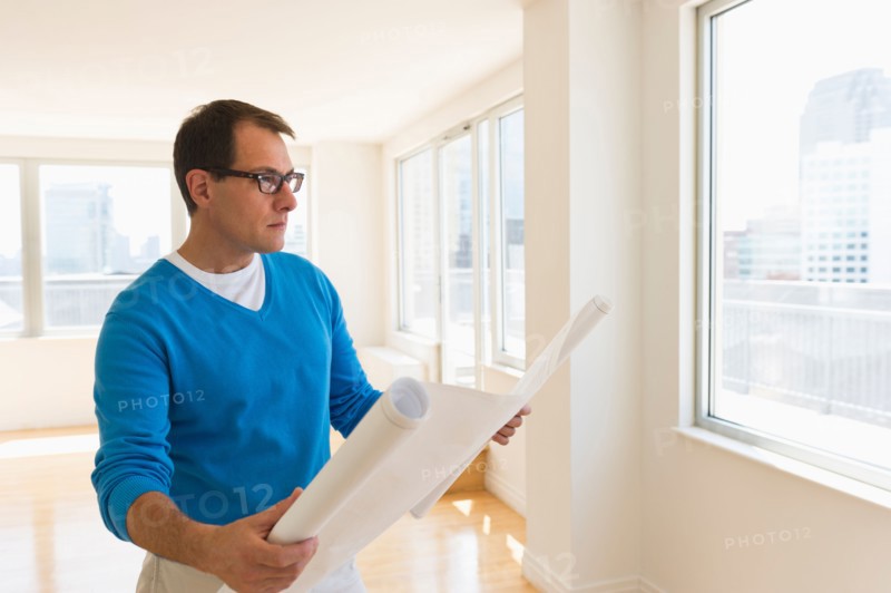 Architect reading blueprint in new office.
