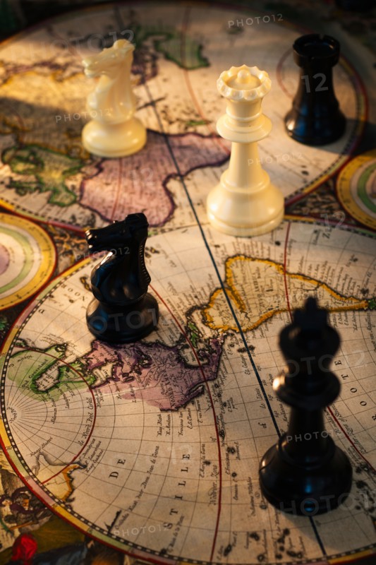 Chess pieces on old world map.
