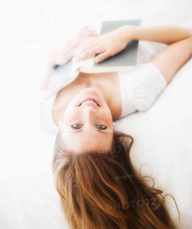 Sensual portrait of young woman reading book. Photo : Daniel Grill
