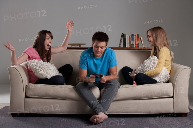 Portrait of teenage boy (16-17) and girl (16-17) with young friend. Photo: Rob Lewine