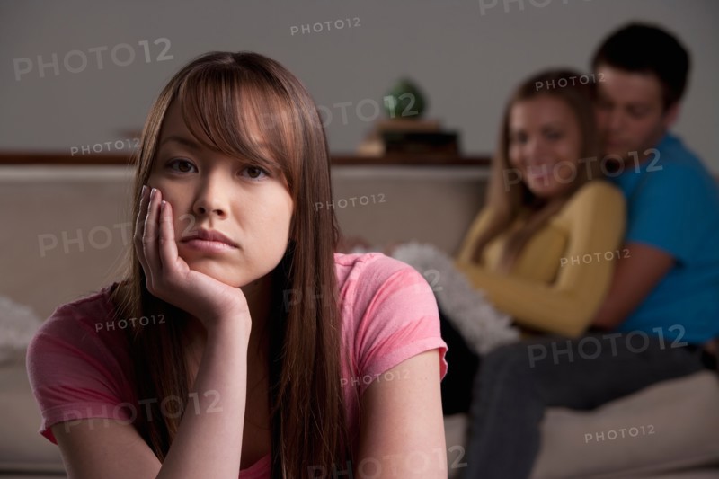 Portrait of teenage boy (16-17) and girl (16-17) with young friend. Photo : Rob Lewine