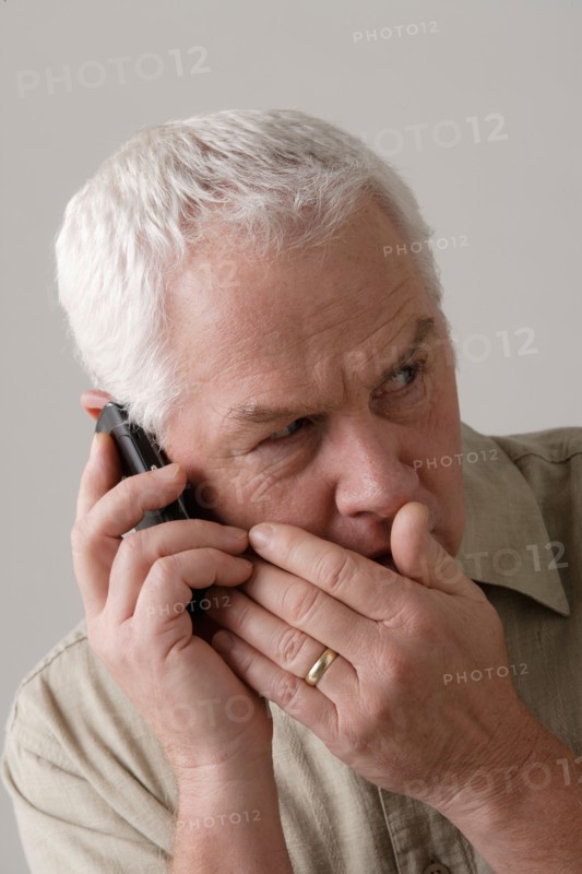 Portrait of senior man with mobile phone, studio shot. Photo : Rob Lewine