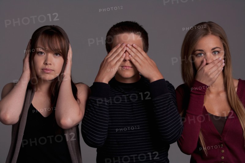 Portrait of teenage boy (16-17) and girl (16-17) with young friend, studio shot. Photo: Rob Lewine