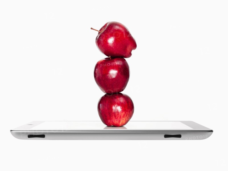 Apples on top of each other on digital tablet, studio shot. Photo : David Arky