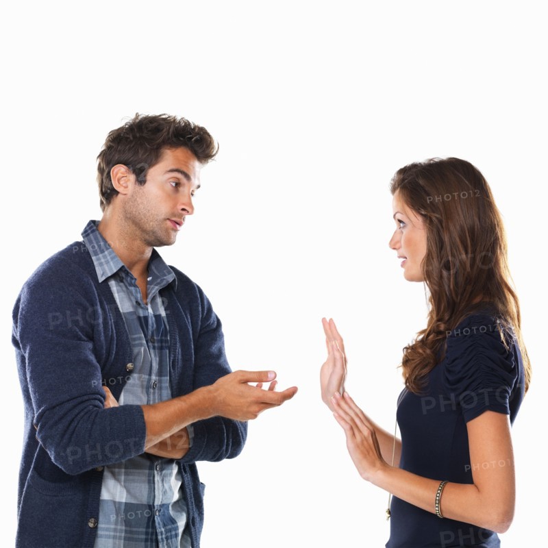 Studio shot of young couple having argument and gesturing. Photo: momentimages