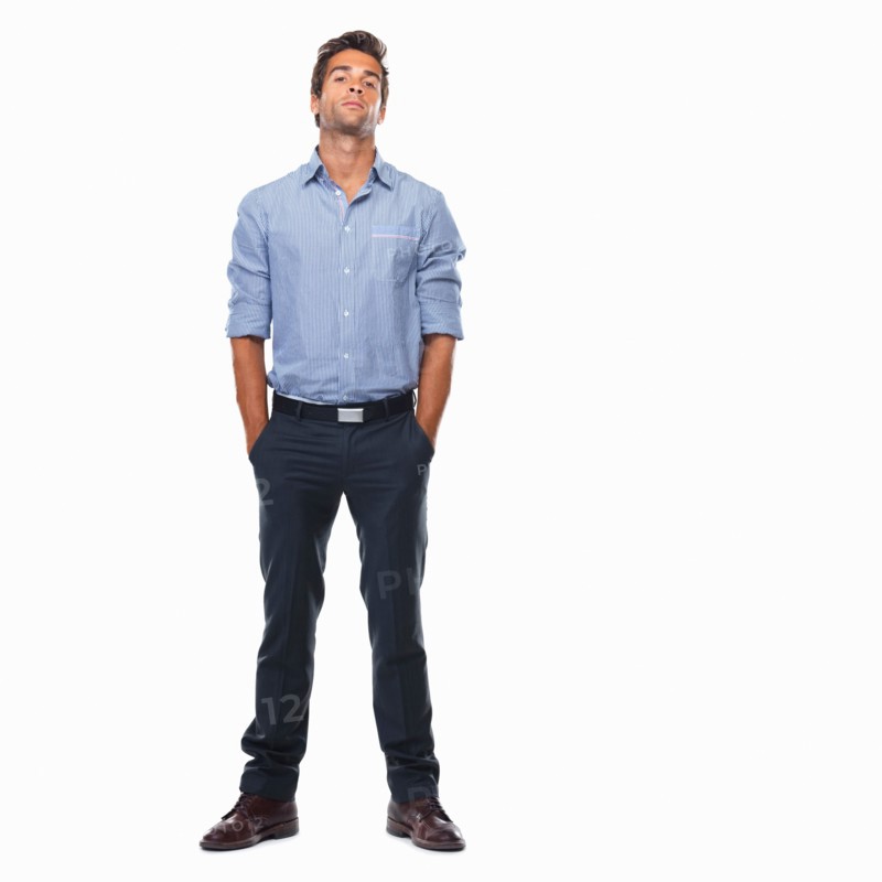 Studio shot of young business man standing with hands in pockets. Photo: momentimages