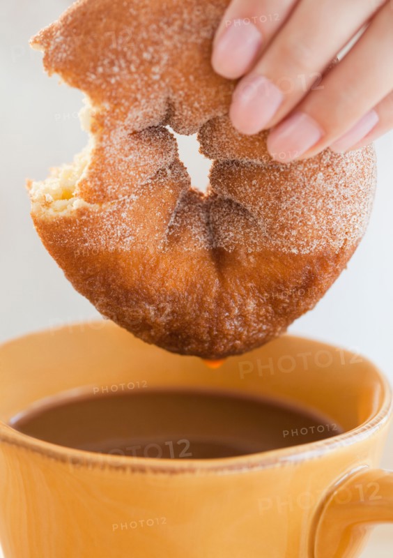 Close up of woman's hand holding donut. Photo: Jamie Grill