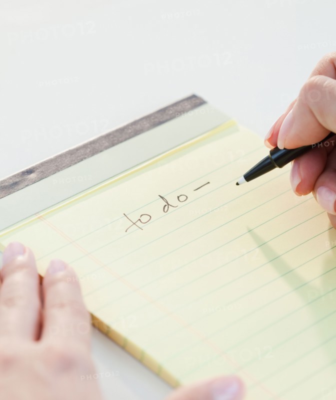 Close up of woman's hands writing list of things to do. Photo : Jamie Grill
