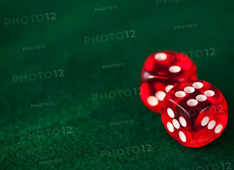 Close up of red dices on green felt. Photo: Daniel Grill