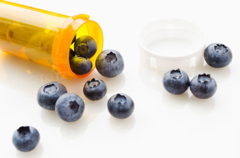 Blueberries spilling from prescription bottle.