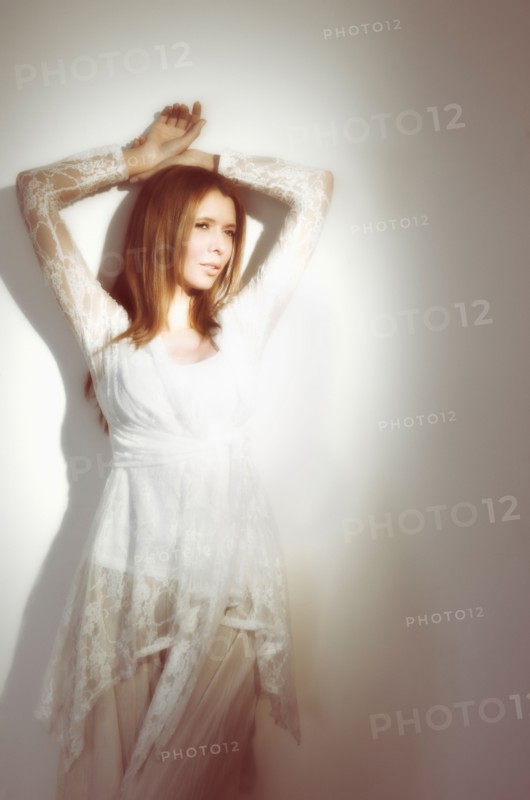 Woman relaxing against wall.