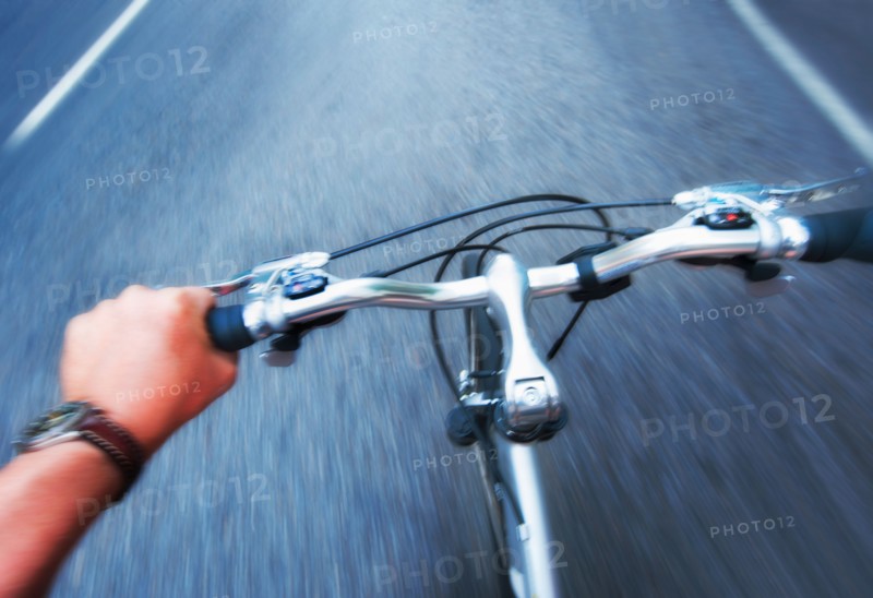 Hand gripping handlebar of bike.