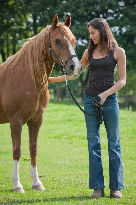 Young woman with horse in field. Photo: Jan Scherders
