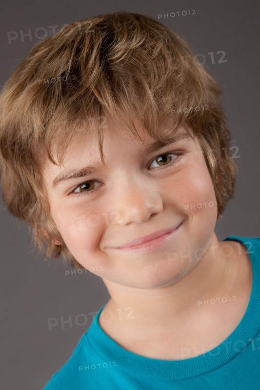 Portrait of smiling boy (8-9), studio shot. Photo: Rob Lewine