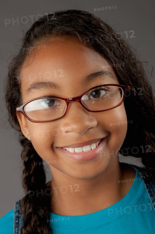 Studio portrait of girl (8-9) wearing eyeglasses. Photo: Rob Lewine