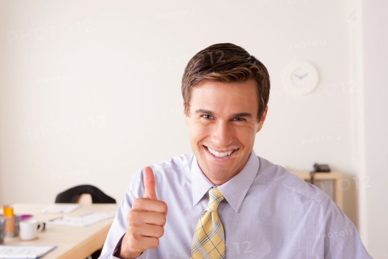 Portrait of businessman with thumbs up. Photo: Rob Lewine