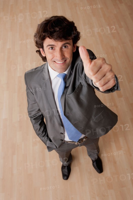 Portrait of mid adult businessman with thumb up. Photo: Rob Lewine