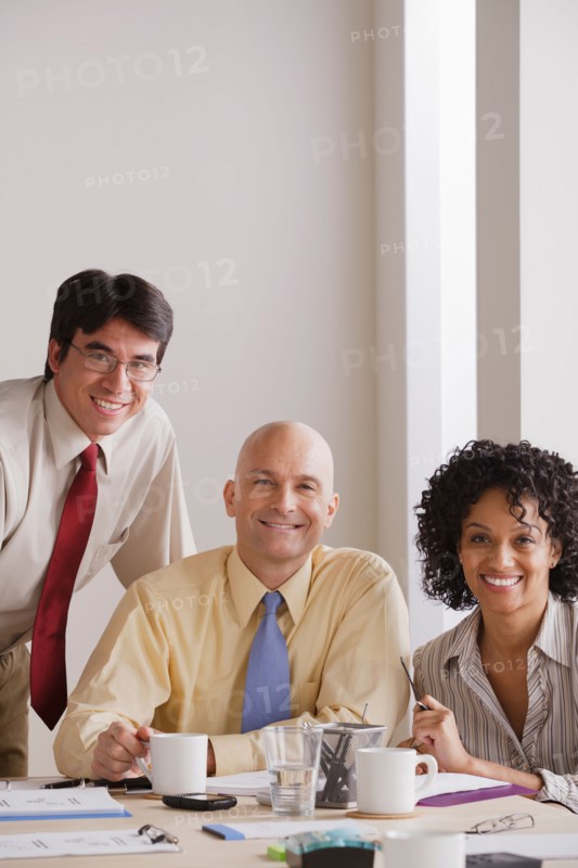 Portrait of smiling business people at meeting. Photo : Rob Lewine