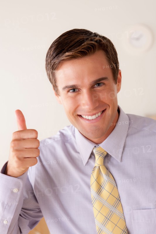 Portrait of businessman with thumbs up. Photo : Rob Lewine