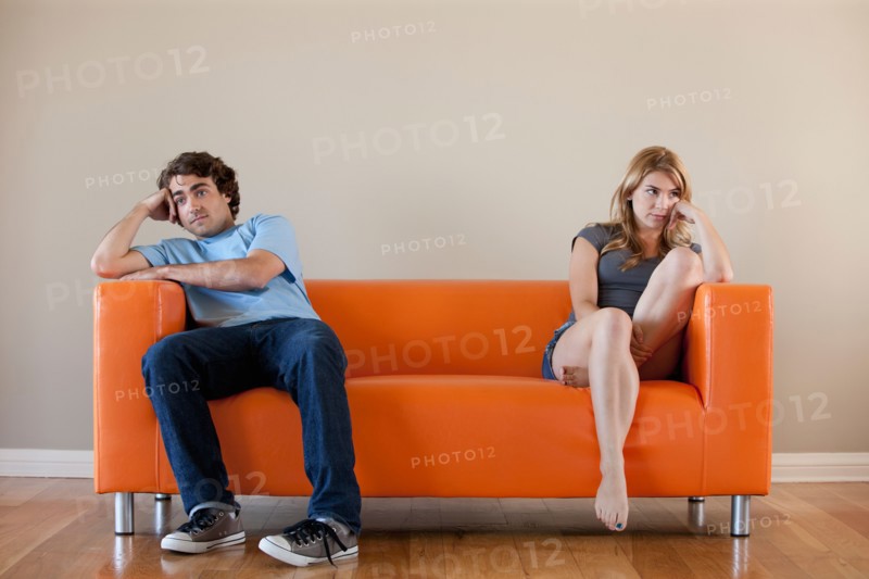Young couple sitting on sofa. Photo : Rob Lewine