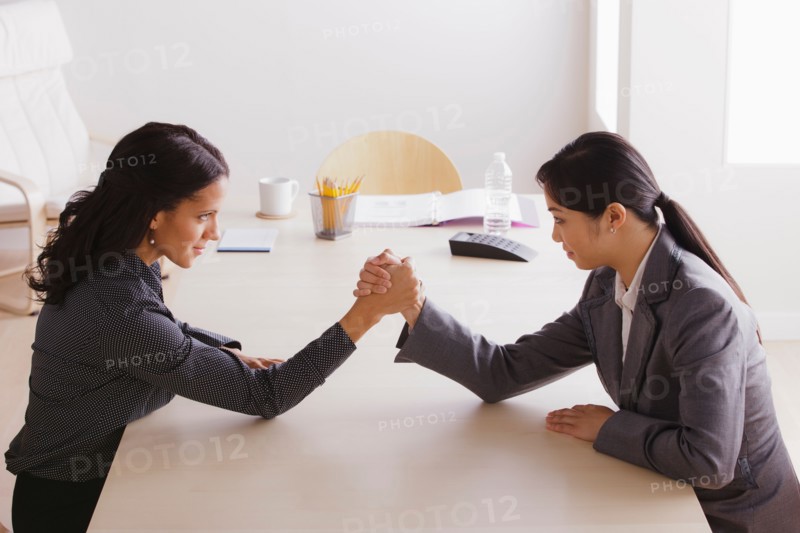 Business man and business woman armwrestling. Photo: Rob Lewine