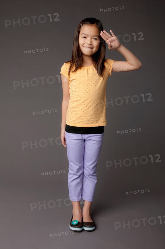 Studio portrait of girl (8-9) saluting. Photo : Rob Lewine