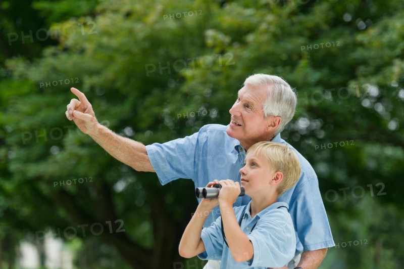 Grandfather and grandson (10-11) in park.