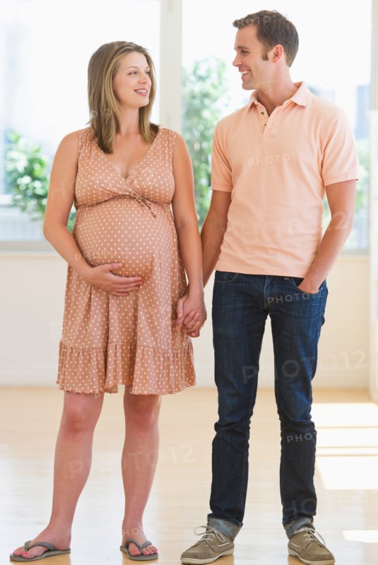 Pregnant woman holding partner's hand.