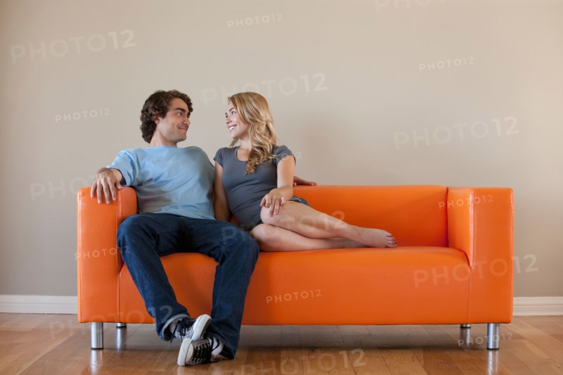 Young couple sitting on sofa. Photo : Rob Lewine