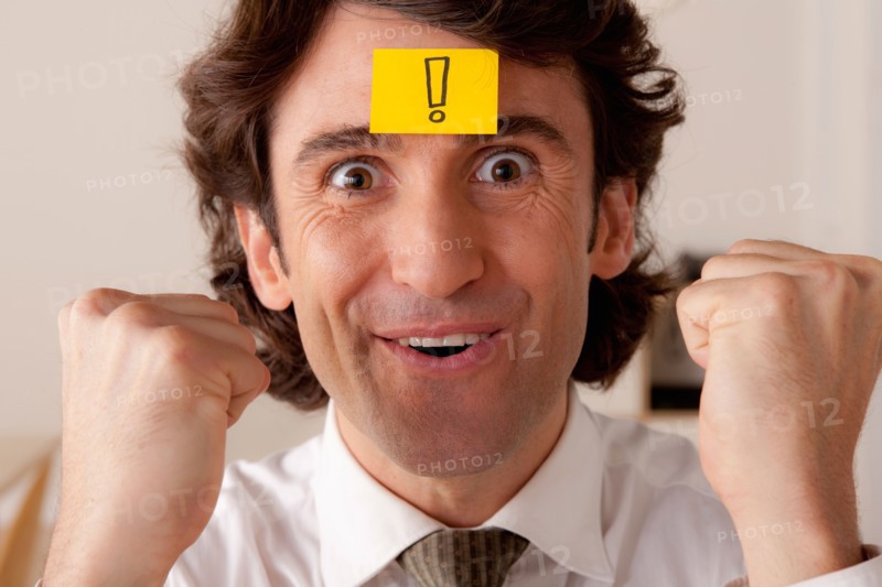 Studio portrait of businessman with adhesive note on forehead. Photo: Rob Lewine