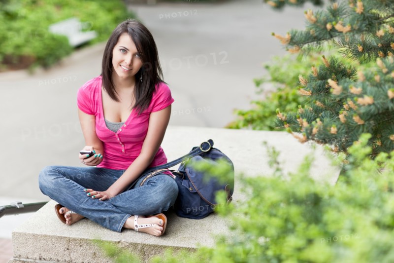Portrait of woman text-messaging in park. Photo: Take A Pix Media