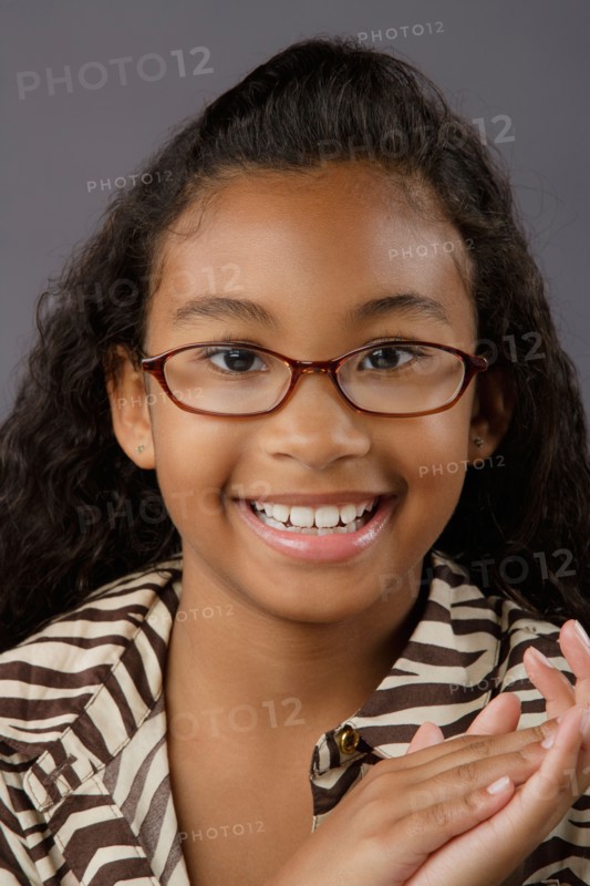 Portrait of smiling girl (8-9), studio shot. Photo : Rob Lewine