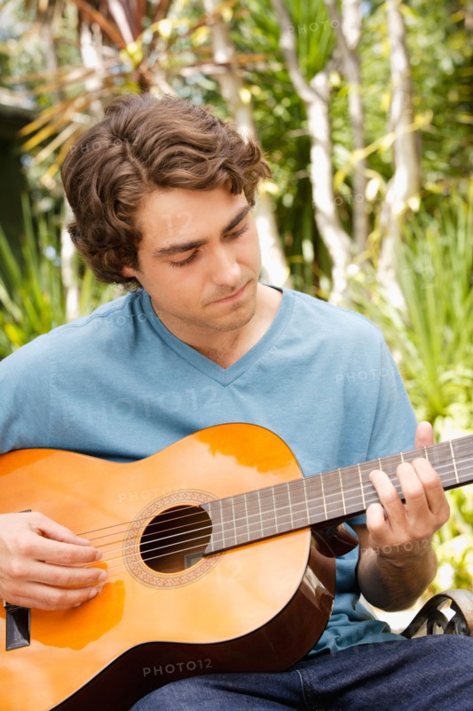Young man playing guitar. Photo : Rob Lewine