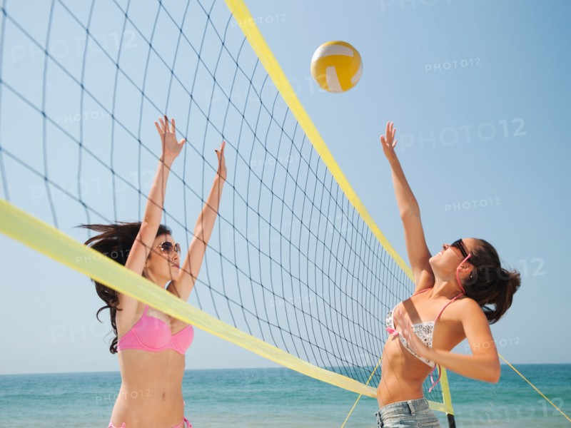 Two attractive young women playing beach volleyball . Photo: Erik Isakson
