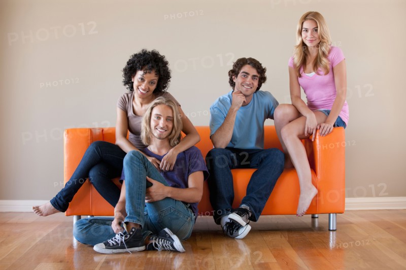Portrait of two couples sitting on sofa. Photo : Rob Lewine
