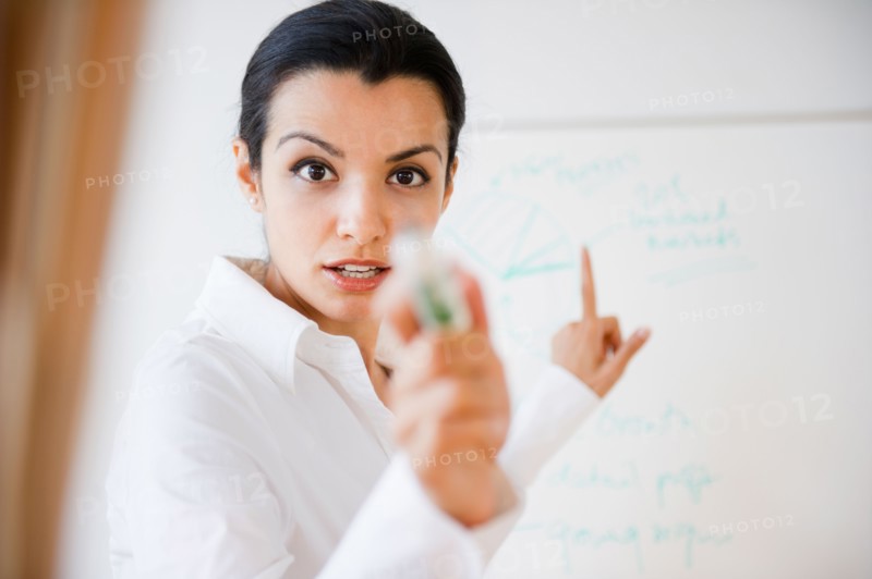 Businesswoman pointing during business meeting. Photo: Jamie Grill