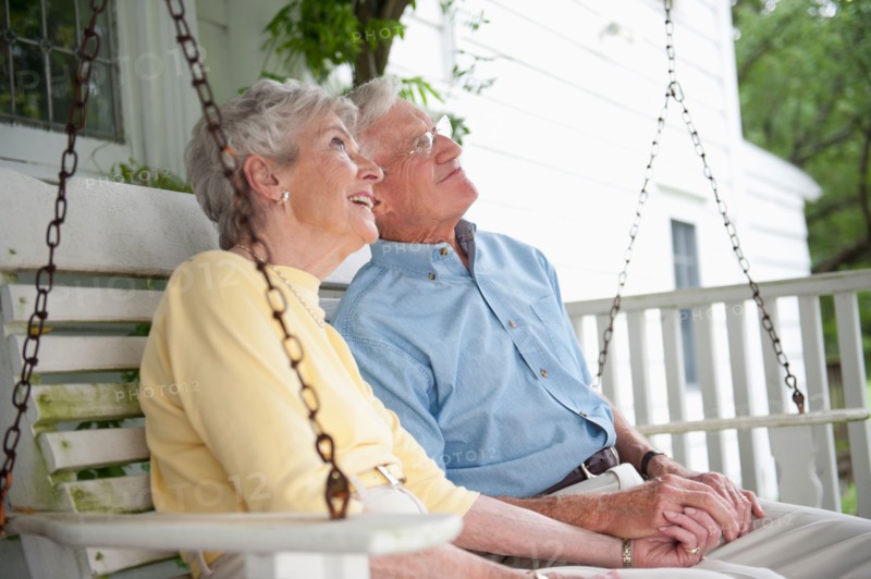 Senior couple sitting on porch swing.