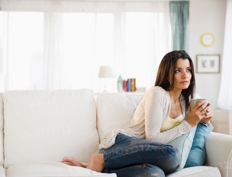 Woman relaxing on sofa . Photo: Jamie Grill