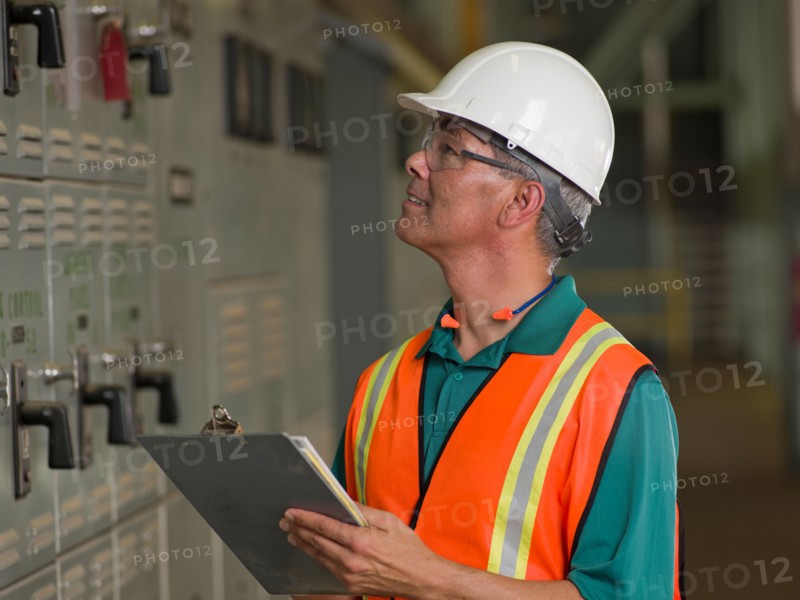 Industrial worker in hard hat writing on clipboard. Photo: db2stock