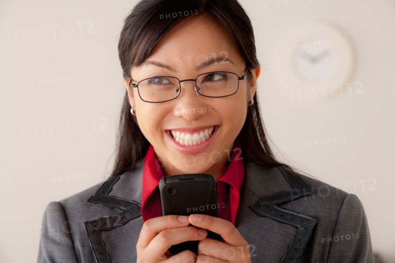 Studio portrait of businesswoman text-messaging. Photo : Rob Lewine