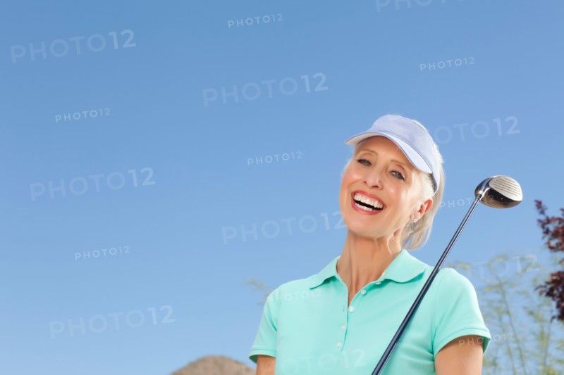 Portrait of mature woman holding golf club. Photo : db2stock
