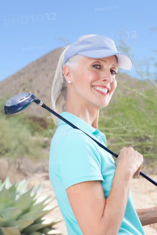 Portrait of mature woman holding golf club. Photo : db2stock