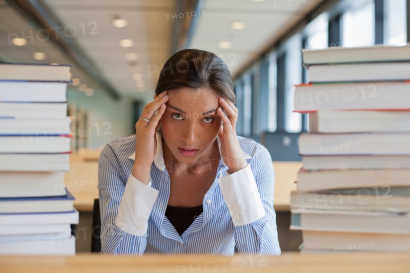 Female student between stacks of books. Photo: Jan Scherders