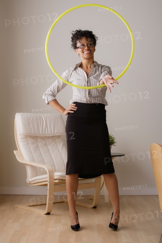 Young businesswoman using hoola hoop. Photo: Rob Lewine